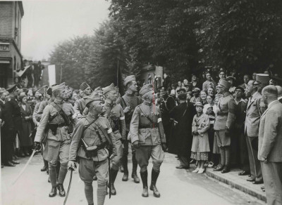 Een detachement Nederlandse militairen defileert te Wijchen op de tweede dag van de 27e Vierdaagse voor ZKH Prins Bernhard (met anjer). Hij wordt geflankeerd door de kapitein E.C. baron van Heeckeren van Brandsenburg en (half zichtbaar) de kapitein J.N. Breunese.