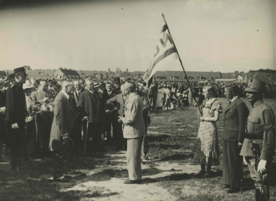 Leden van het Nationaal Jongeren Verbond bieden hun gelukwensen aan tijdens de vlaggenparade op het Molenveld op de maandagmiddag van de 25e Vierdaagse. Uiterst links kapitein J.N. Breunese, met snor NBVLO-voorzitter jonkheer G.C. von Weiler, naast hem in civiel adjudant K. Boessenkool en met zijn handen in de zij (half zichtbaar) de burgemeester van Nijmegen de heer J.A.H. Steinweg.