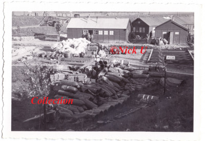 4:De Nederlandse barrakken van 1-17 Regiment Artillerie veroverd door de Duitsers. Let vooral op de hopen Parachutes en de droppingscontainers. Aan voorraden geen gebrek!