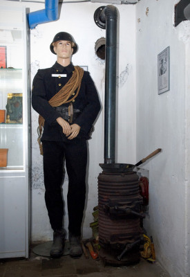 Een LBD-man die er warmpjes bijstaat<br />naast de bunkerkachel.